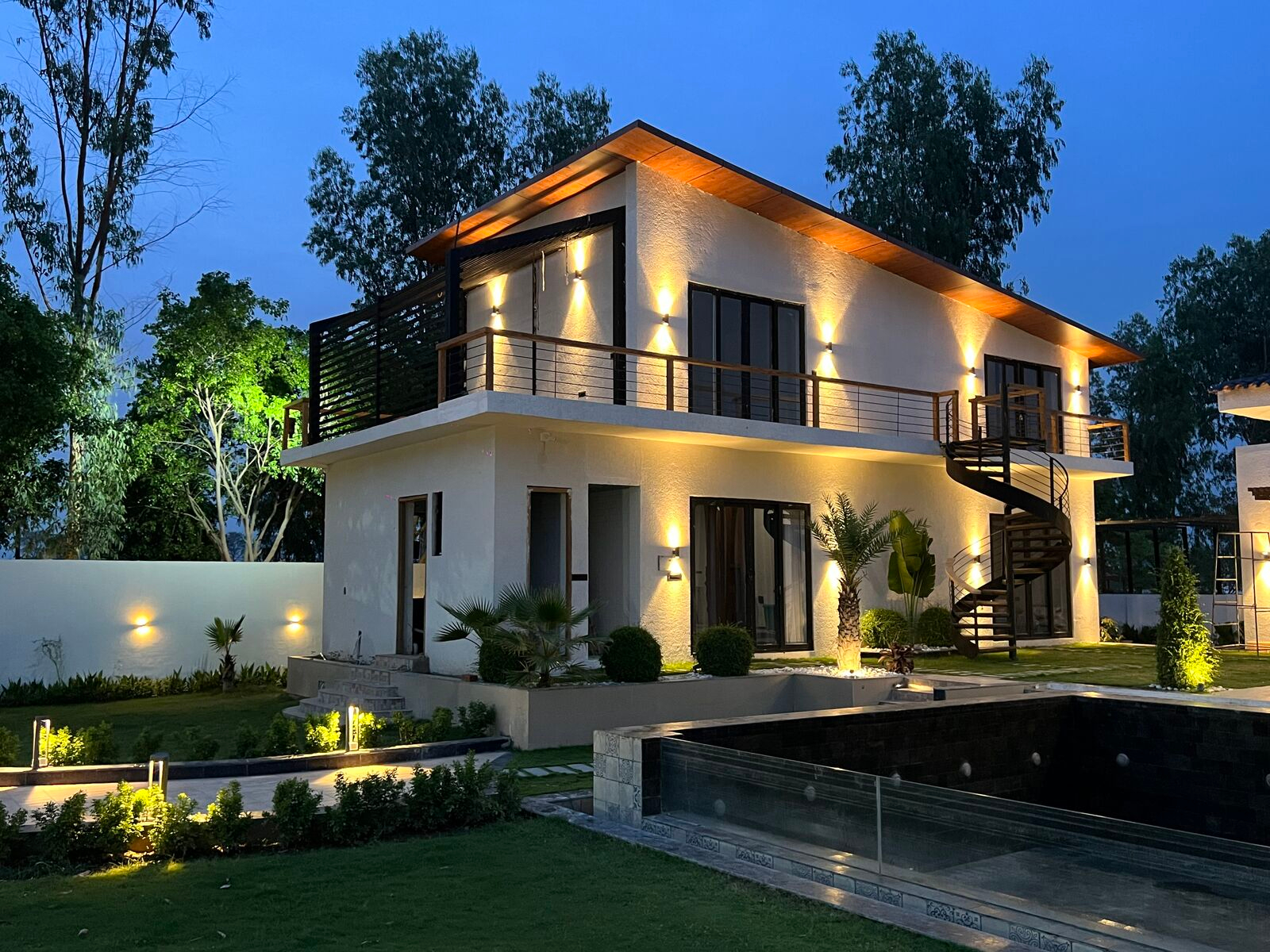 Urban Euphoria Bali-themed luxury villa glowing at dusk beside its private reflecting pool, Lucknow