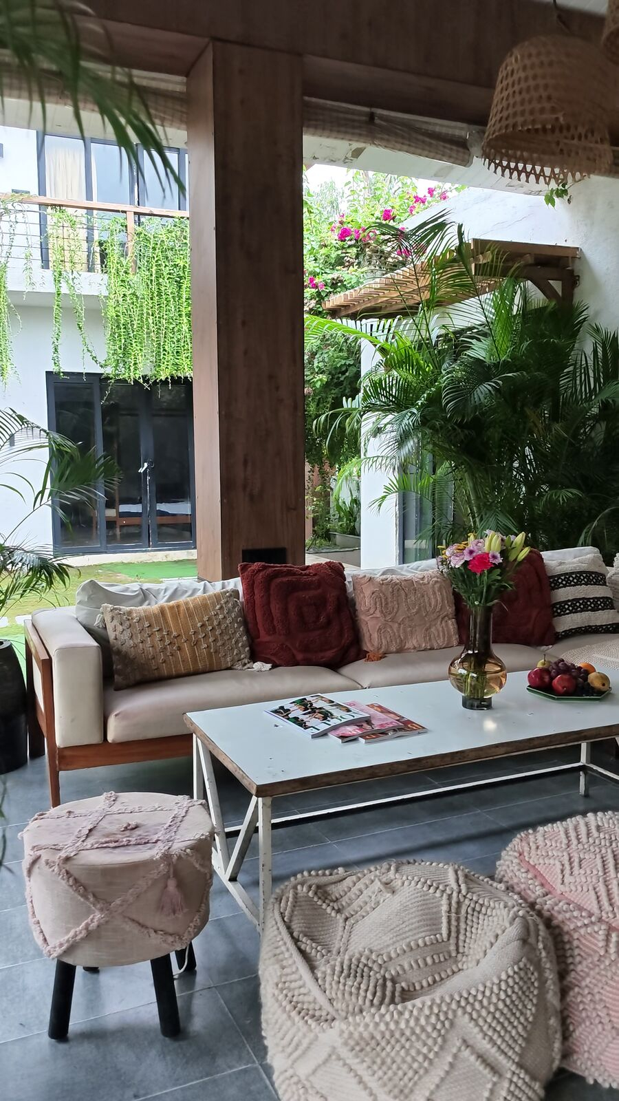 Cosy lounge corner with fresh flowers, cushions and boho poufs