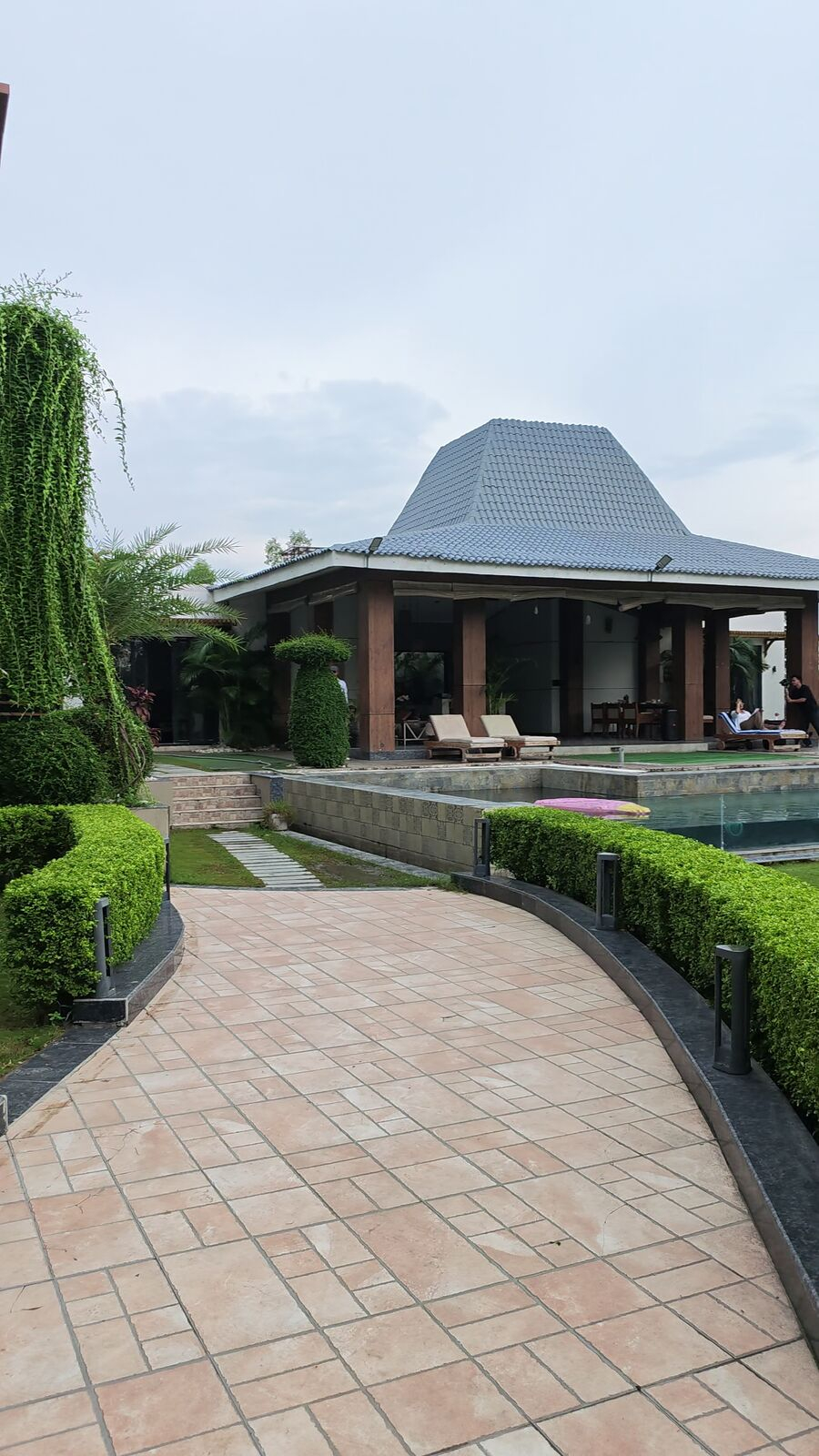 Paved pathway leading to the poolside pavilion and pool deck