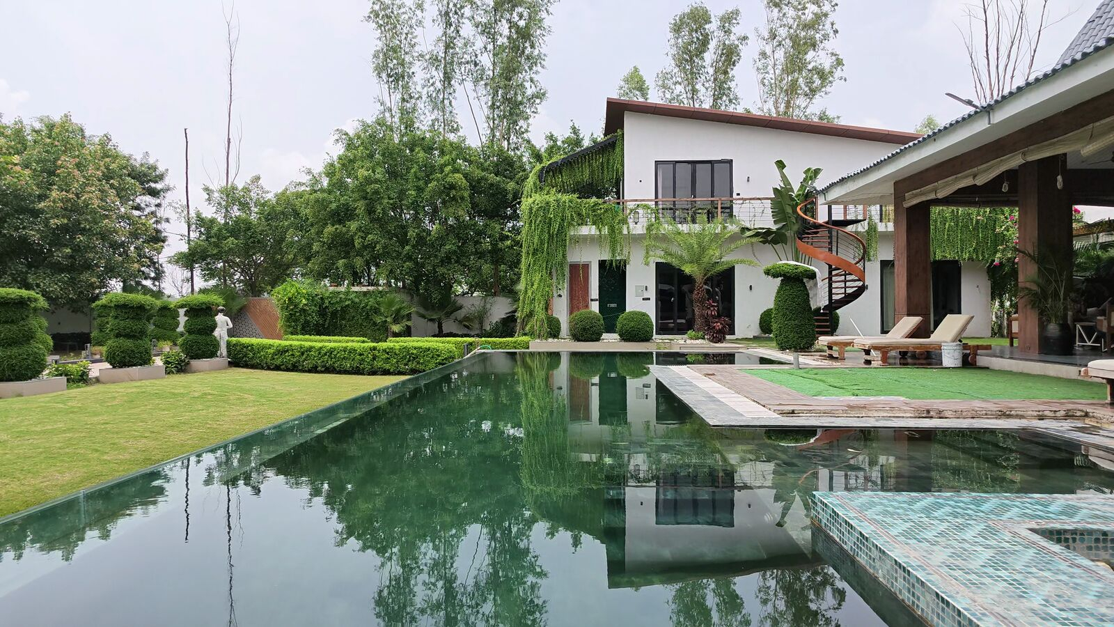 Emerald private swimming pool with the villa and manicured lawns behind
